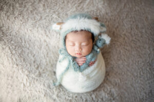 干支の飾りと一緒に赤ちゃんを包んで撮影したおひなまきのニューボーンフォト_ポテトサック（吹田のフォトスタジオふみる）