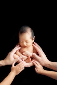 パパとママの手に包まれる赤ちゃんのニューボーンフォト（豊中市のふみる）