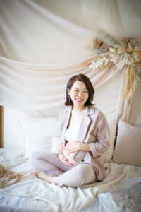お腹に手を添える妊婦さんを柔らかい光で撮影したマタニティフォト_レンタルカジュアル衣装_吹田市のフォトスタジオふみる