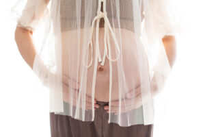 お腹に手を添える妊婦さんを柔らかい光で撮影したマタニティフォト_吹田豊中フォトスタジオFumiruふみる