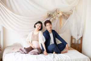 夫婦で手を繋ぐ_妊婦さんを柔らかい光で撮影したマタニティフォト_吹田・豊中フォトスタジオ